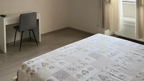 A bedroom with a bed, a desk, a chair, a TV, and a window with curtains. - La piazzetta Anzio (Anzio)