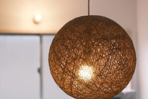 A spherical, woven light fixture with a visible bulb inside, hanging from a ceiling. - Fuku Guesthouse (Osaka)