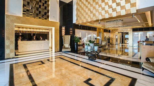 A spacious lobby with a reception desk, seating area, and a checkered wall pattern. - DAMAC Maison Mall Residences - Downtown (Dubai)