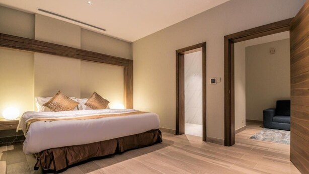 A modern hotel room with a large bed, wooden flooring, and a minimalist design. - Tiara Quraish (Jeddah)