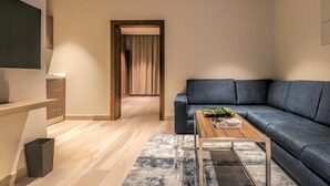 A modern living room with a sofa, a coffee table, and a TV. - Tiara Quraish (Jeddah)