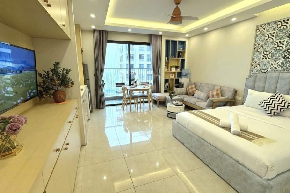 Habitació d'hotel moderna amb llit, sofà, televisió i un balcó amb vistes.