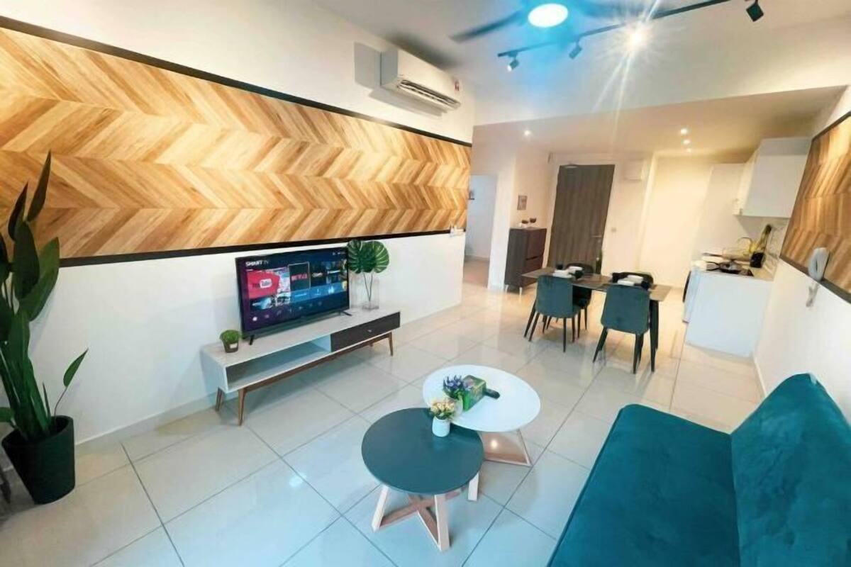 Een moderne woonkamer met een televisie, twee ronde tafels, een bank en een eethoek.