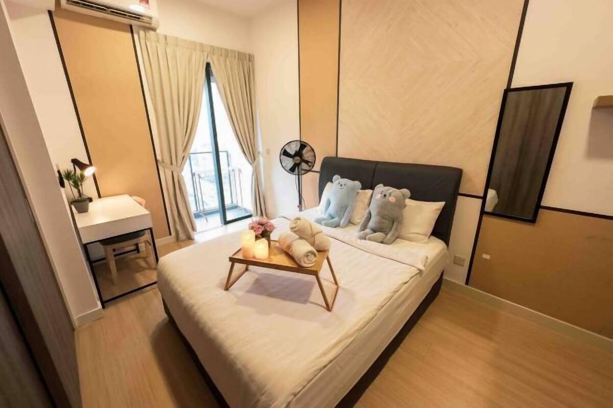 Een hotelkamer met een bed, nachtkastje, lamp en een raam met gordijnen.