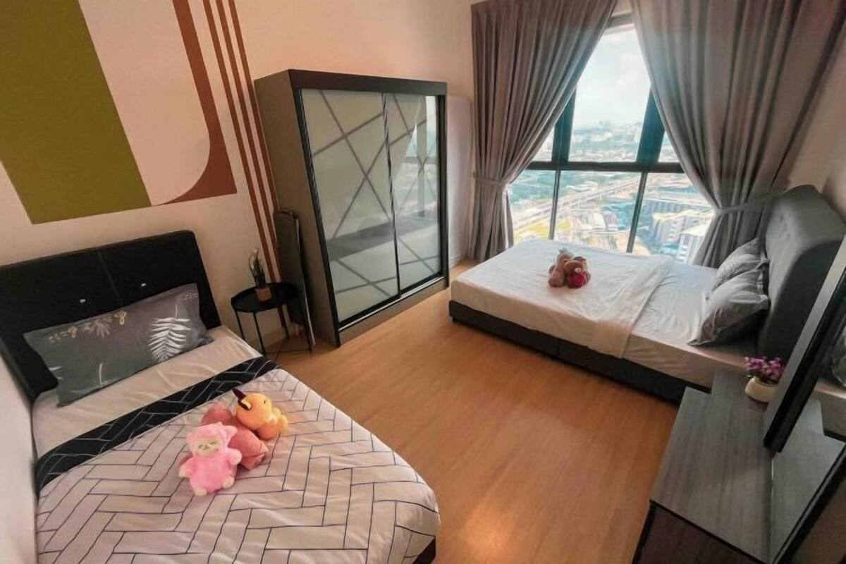 Een hotelkamer met een bed, een kledingkast, een klein tafeltje en een raam met uitzicht op de stad.