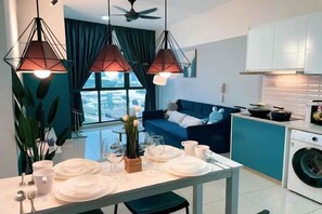 Een moderne keuken met een eethoek, een wasmachine en uitzicht op de stad.