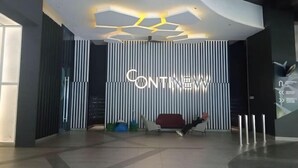Ein modernes Interieur mit einem 'CONTINENT'-Schild, einem roten Sofa und einem außergewöhnlichen Deckenstil.