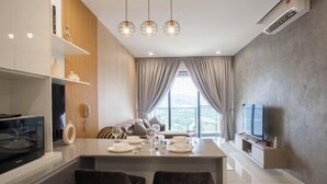 Eine moderne Küche mit Essbereich, einem Fernseher und einem großen Fenster.