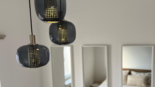 A modern bedroom with a large bed, a nightstand, and a mirror. - Urban Luxury Apartment Zagreb  One  Bedroom Apartment (Zagreb)