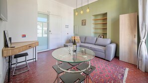 A modern living room with a glass dining table, grey sofa, and a wooden cabinet. - 2 Rooms with Balcony Hypercentre A1B162 (Cannes)