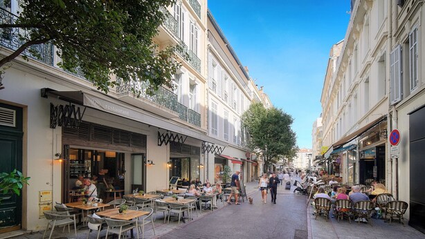 A narrow street lined with cafes and restaurants, outdoor seating, and pedestrians. - 2 Rooms with Balcony Hypercentre A1B162 (Cannes)
