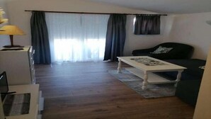 A living room with a sofa, a coffee table, and a lamp.