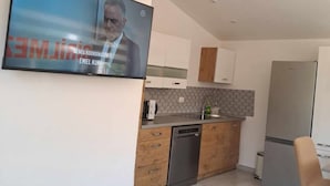 Una cocina moderna con armarios de madera, un refrigerador de acero inoxidable y un lavavajillas.
