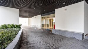 Ένας διάδρομος με ένα διακοσμητικό ταβάνι, ένα δάπεδο από τούβλα και μια ζαρντινιέρα με φυτά στη μία πλευρά.