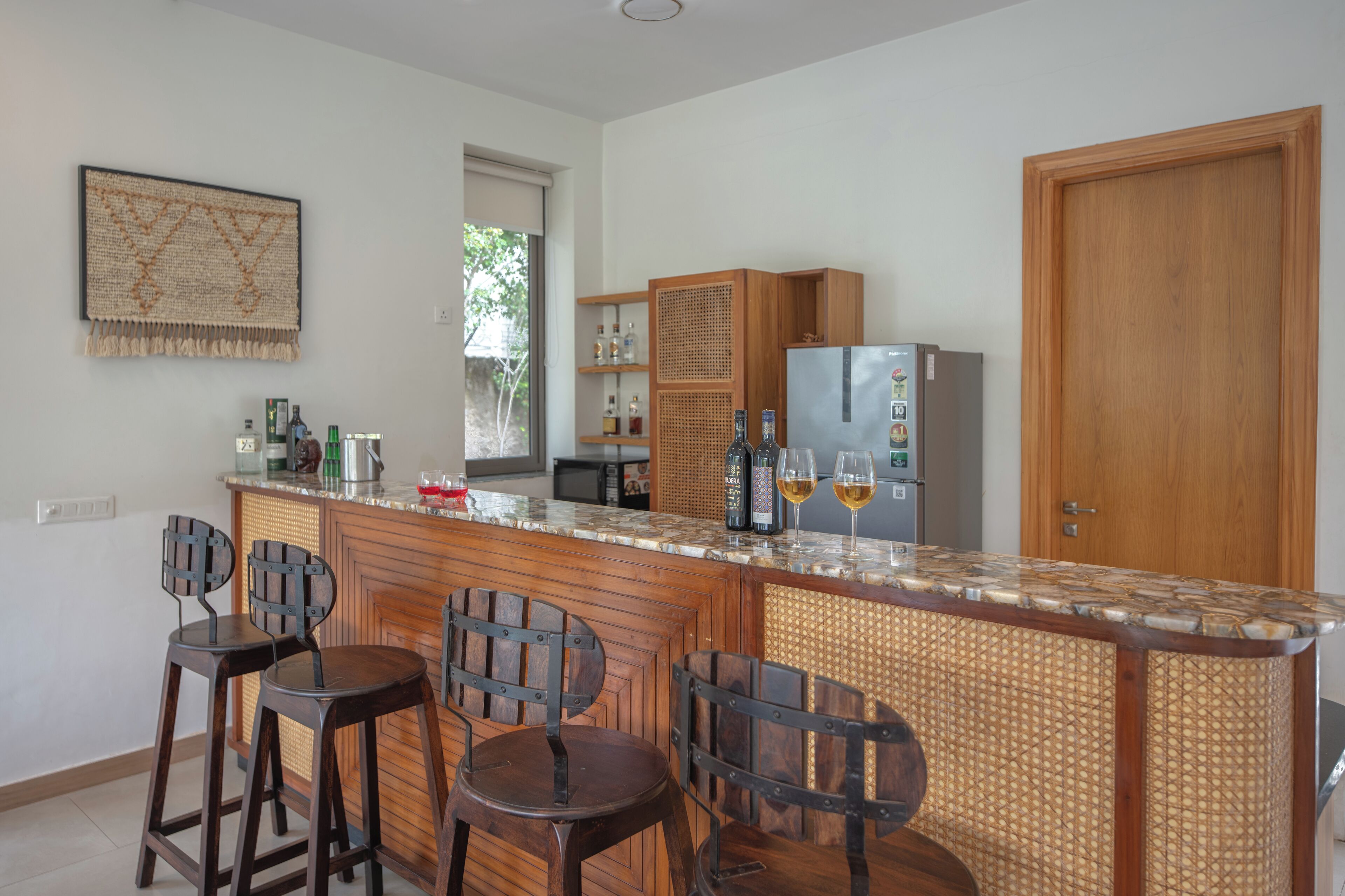 Eine Küche mit Bar, Holzstühlen, einem Kühlschrank und einem Fenster mit Blick.