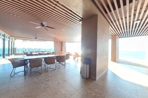 Comedor de concepto abierto con techo alto y vista al mar.