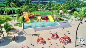 A beach area with a pool, slides, and decorative crab figures. - Forest City Carnelian Tower Summer Home Day Hotel（Infinity pool） (Gelang Patah)