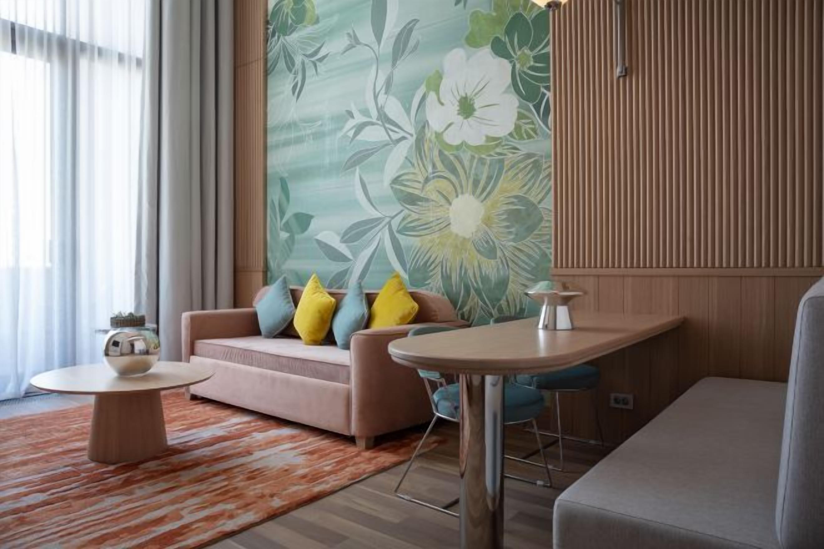A modern living room with a sofa, round coffee table, and a bar stool.