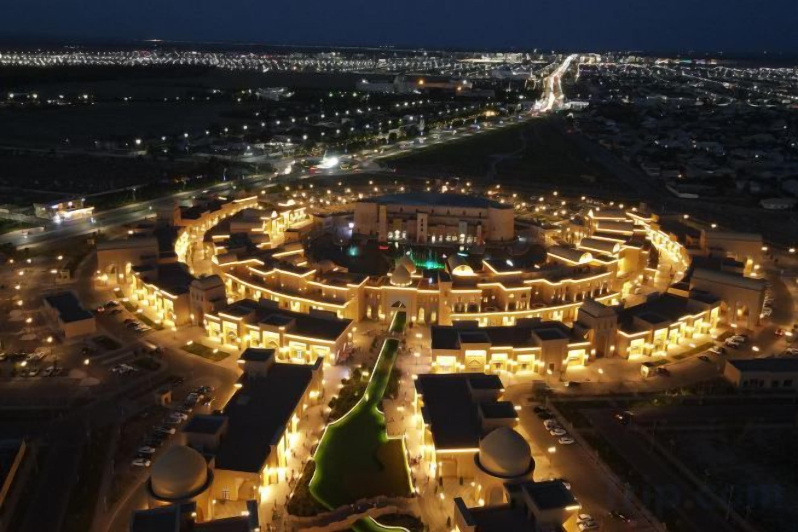 Un edifici complex de forma circular amb diversos nivells i un pati central, envoltat per carreteres i altres edificis.