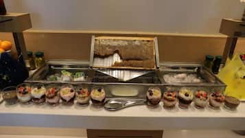 A buffet with a variety of desserts and a honeycomb display.