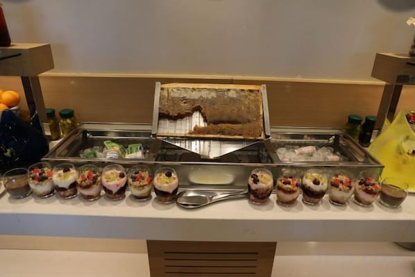 A buffet with a variety of desserts and a honeycomb display.