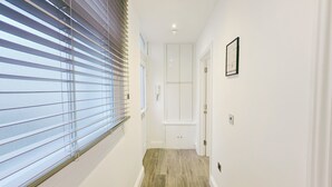 Ein Flur mit Fenster, einer Tür und einer kleinen Stufe, die in einen anderen Raum führt.