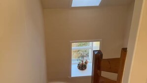 A wooden staircase with a skylight and a window. - Cosy House in the heart of Kirkwall (Kirkwall)