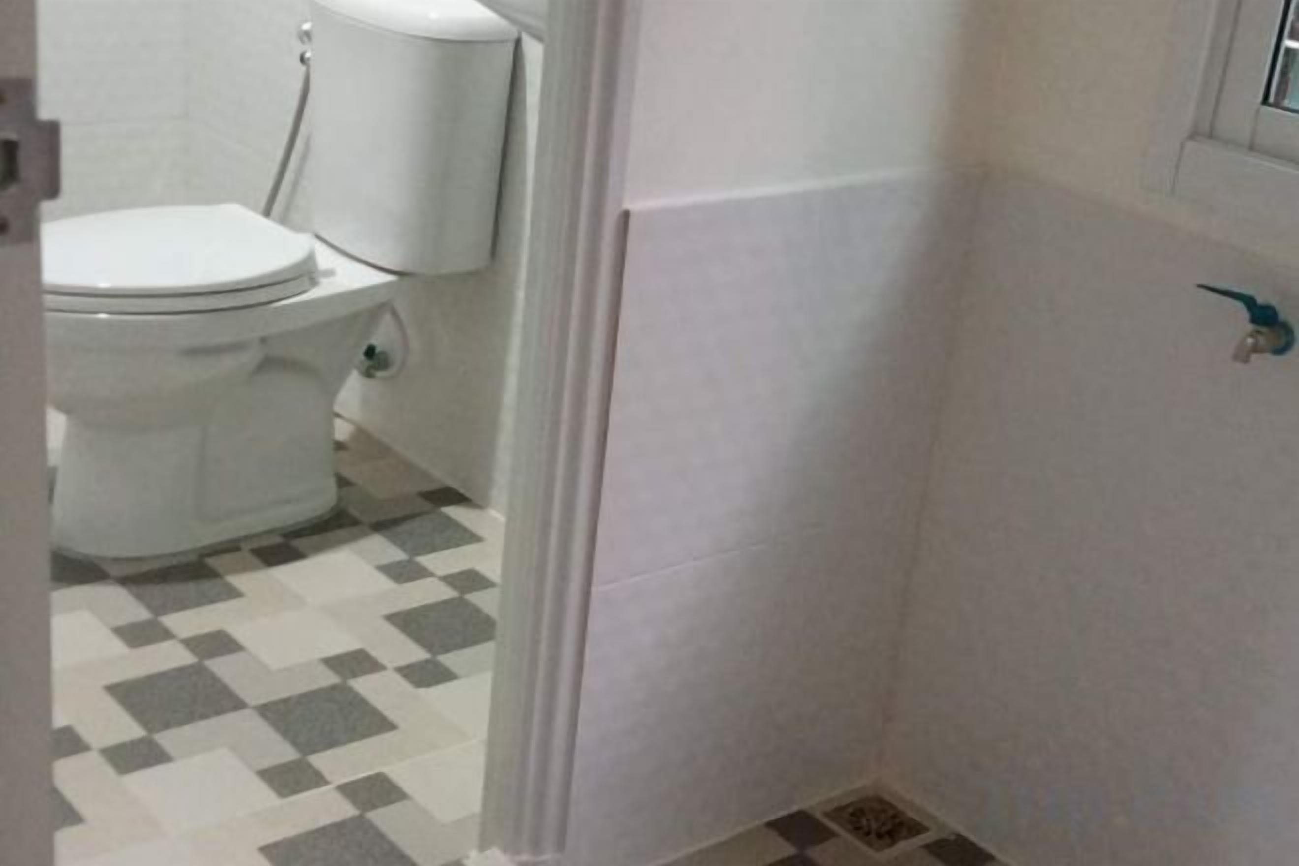 A bathroom with a toilet, a sink, and a shower area.