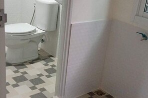 A bathroom with a toilet, a sink, and a shower area. - Baan Wira Guesthouse (Khon Kaen)