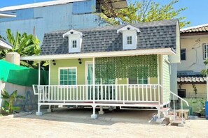 A single-story house with a porch, a small attached garage, and a green fence. - Baan Wira Guesthouse (Khon Kaen)