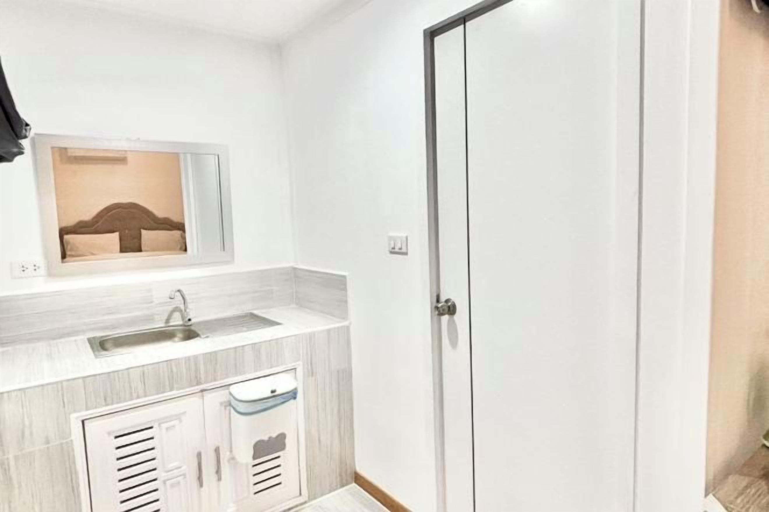 A modern bathroom with a sink, mirror, and storage cabinets.