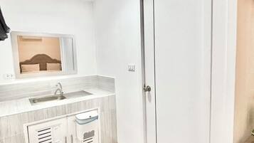 Un baño moderno con lavamanos, espejo y armarios de almacenamiento.