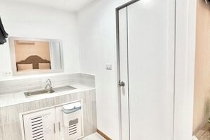 Un baño moderno con lavamanos, espejo y armarios de almacenamiento.