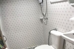 A bathroom with a shower, toilet, and sink.