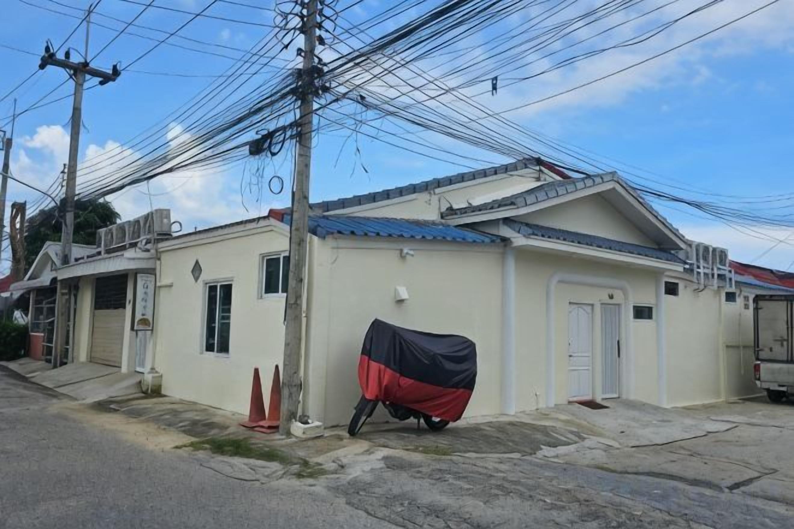A single-story building with a flat roof, a covered entrance, and a visible door.