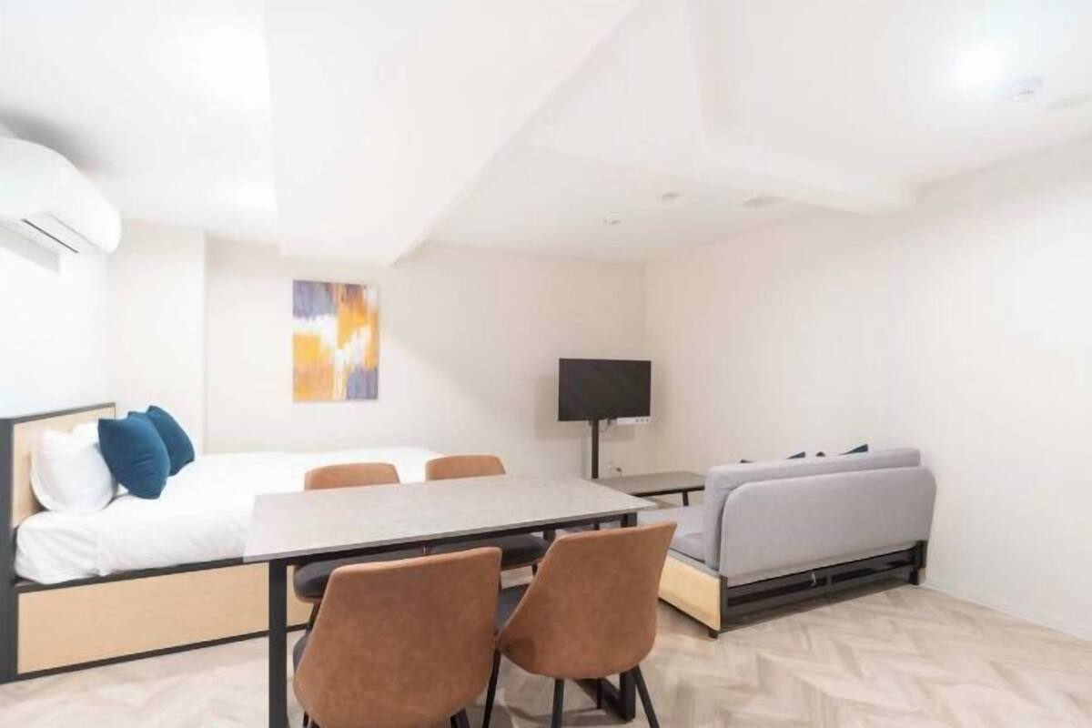 Une chambre moderne équipée d’un lit, d’un canapé, d’une table à manger, de chaises et d’un téléviseur.
