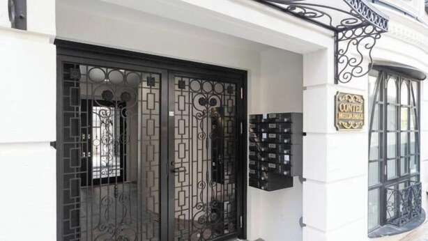 A white building with a black ornate gate and a sign that reads "CONTEL MEDIANALE". - CONTEL Meidaimae (Tokyo)
