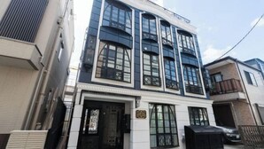 A multi-story building with large windows and a central entrance. - CONTEL Meidaimae (Tokyo)