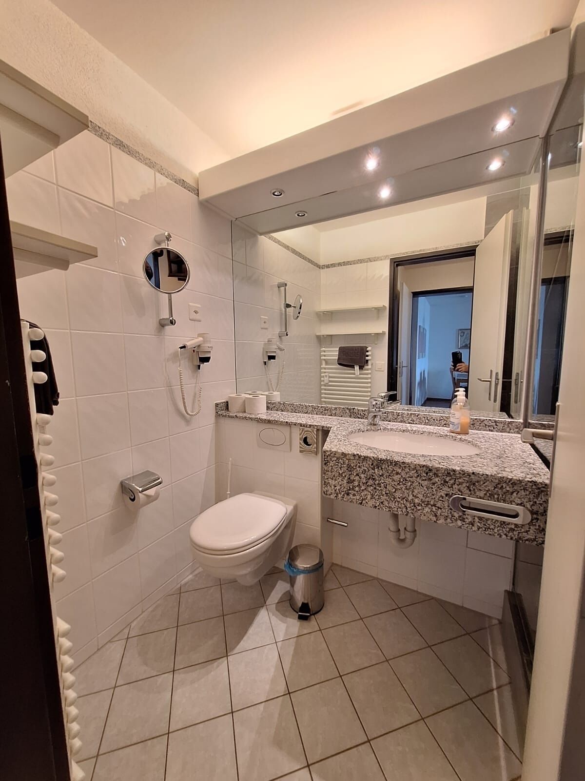 Une salle de bain moderne équipée de toilettes, d’un lavabo et d’une douche.