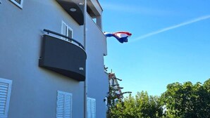 Ein Gebäude mit einem Balkon und einer Flagge.