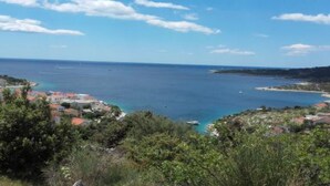 A coastal town with buildings along the shoreline, a clear blue sky, and a view of the sea. - Apartments Milakovic-Kanica - One Bedroom Apartment with Sea View and Terrace (Rogoznica)