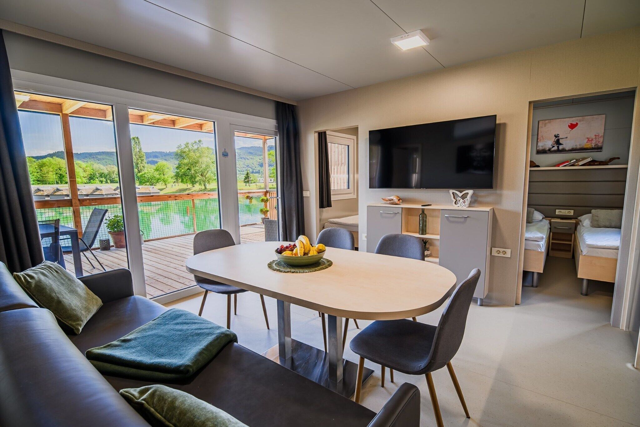Ett modernt hotellrum med en matplats, en TV och en balkong med vacker utsikt.