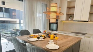 A modern dining area with a wooden table, grey upholstered chairs, and a large pendant light.