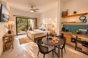 A modern hotel room with a bed, a dining area, and a kitchen. - Luxury Seaside Villa For 8 adults! Beach & Surf-Hot Spa-Infinity Pool (Vinoramas Diamante)