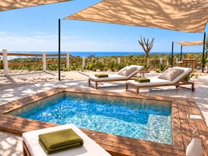 A pool area with lounge chairs and a view of the ocean. - Luxury Seaside Villa For 8 adults! Beach & Surf-Hot Spa-Infinity Pool (Vinoramas Diamante)