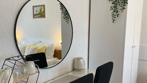 A hotel room with a bed, a round mirror, a small table with a kettle, and a chair. - Double room with double bed 2 (Rakovica)