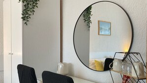 A hotel room with a round mirror, a bed with a yellow pillow, a coffee machine, and a tray with cups and a mug. - Double room with double bed 2 (Rakovica)