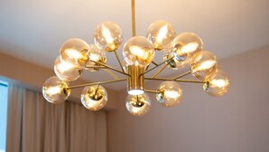 Un lampadario con diverse lampade sferiche in vetro e una struttura in metallo dorato.