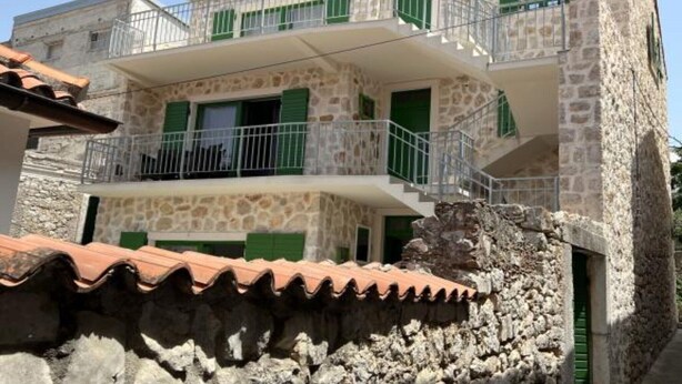 A two-story stone building with green shutters and a balcony. - Apartments Stone House Murter - Two Bedroom Apartment (Murter)