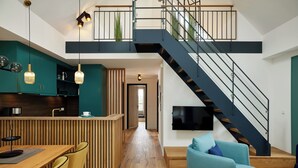 Un appartement moderne comprenant une cuisine, un coin repas, un salon et un escalier.